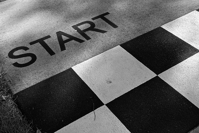 A photo image of the word START painted on concrete and a black and white checkered pattern painted beneath it.