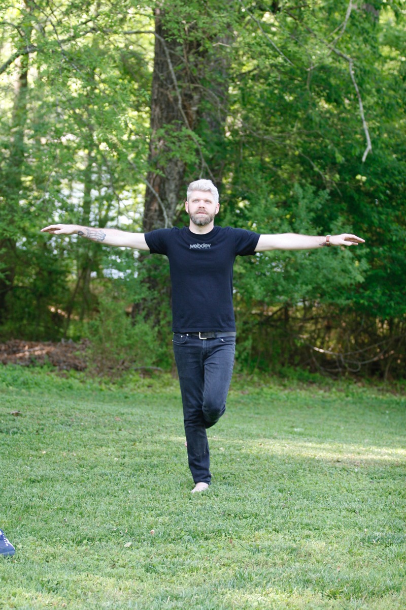A photo image of WebDevStudios Lead Frontend Engineer, Corey Collins, in the flamingo pose (standing on one leg). Corey is the author of the blog post, "Breaking the Cycle of the Mean Developer."