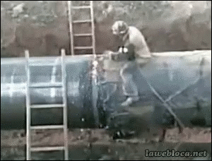 This is a GIF of a construction person sitting on a very large pipe, working on it, when it suddenly explodes, pushing the worker off. The worker walks away fine.