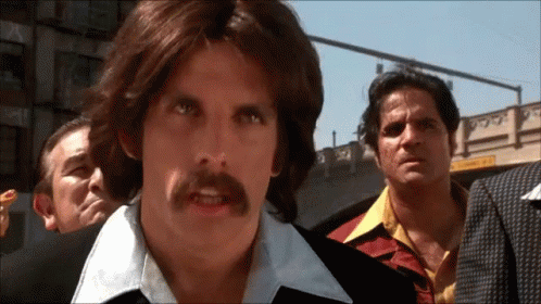 This is an animated GIF from Anchor Man. The GIF features Ben Stiller's character saying, "Of course."