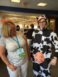 This is a photograph of Senior Backend Engineer, Brad Parbs, dressed in a black and white cow suit while COO, Lisa Sabin-Wilson looks on.