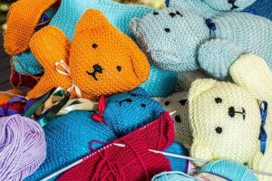 This is a close-up photo of a pile of hand-knitted from yarn teddy bears.