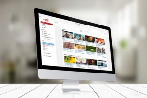 A photograph of a monitor with the YouTube home page displayed.