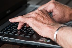 This is a photograph of a pair of hands at work typing on a keyboard.
