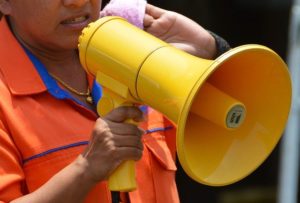 This is a photo of a bright yellow megaphone held by a person.