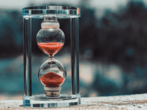This is an outdoor image of an hourglass with red sand.