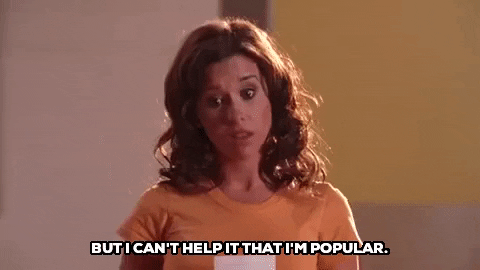 This is a GIF from the movie Mean Girls. It shows one of the characters saying, "But I can't help it that I'm popular."