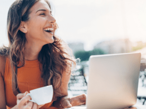 This is an image of a woman at a laptop with a cup of coffee and she looks very happy with her UX experience.