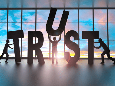 People pushing life-size letters to spell out trust.