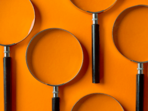 Magnifying glasses on an orange background.